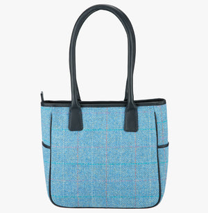 This is the reverse of the Harris Tweed tote bag with handles that go over the shoulder. This bag is sky harris tweed with black leather handles. It has a pocket on each side of the bag trimmed with black leather. 