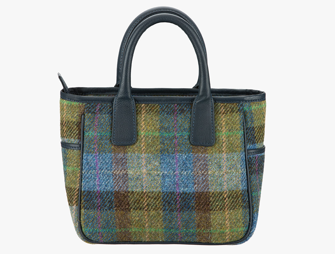 his is the reverse of the Harris Tweed handheld bag in denim check. This bag's colour is blue, green and brown check. It has a pocket on each side of the bag trimmed with navy leather.