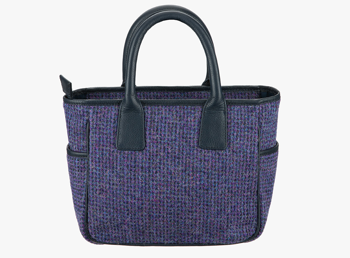 This is the reverse of the Harris Tweed handheld bag. This bag's colour is violet and back fine check. It has a pocket on each side of the bag trimmed with black leather.