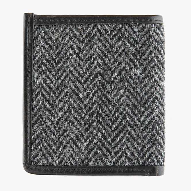 This is the rear view of the Harris Tweed card and note holder in charcoal herringbone, it is a grey and black small herringbone design, it is complimented in black leather. 