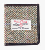 This is the front of the Harris Tweed card holder in pastel check, it is a cream and brown small herringbone design with a blue and pink overcheck.  It is trimmed in brown leather. This card and note holder has room for 6 cards and a slot to hold your banknotes. It has a rectangular Harris Tweed logo on the front.  