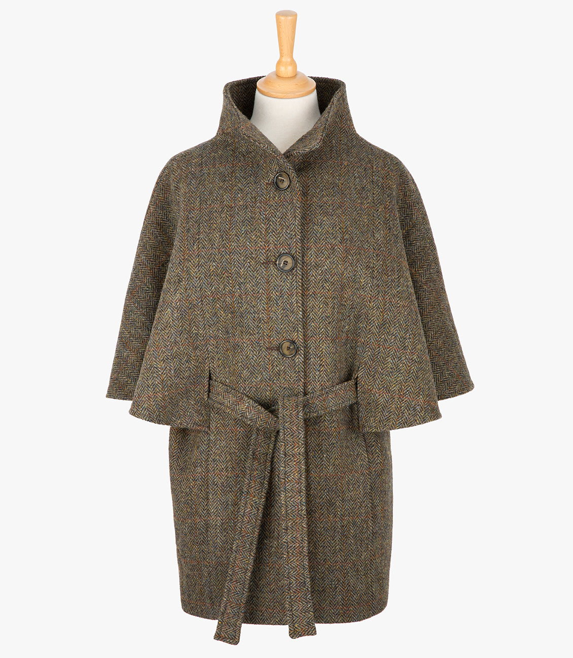 Harris Tweed belted cape in Brown herringbone. The cape has 4 buttons, a belt and a collar that can be worn up or folded down. It also has two pockets. It is a traditional cape style at the top but slightly more fitted through the hips. It has a stunning silky lining and comes in sizes small to large.
