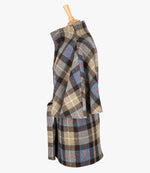 This is the side view of the belted cape in Camel check, the colour is brown and taupe check, with an orange and white overcheck. You can see the collar stood up and the sleeves of the cape which come mid-way down the arm. It has two pockets and ties at the waist for a neat silhouette.