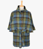 Harris Tweed belted cape in denim sage, the colour is blue, brown and green check. The cape has 4 buttons, a belt and a collar that can be worn up or folded down. It also has two pockets. It is a traditional cape style at the top but slightly more fitted through the hips. It has a stunning silky lining and comes in sizes small to large.