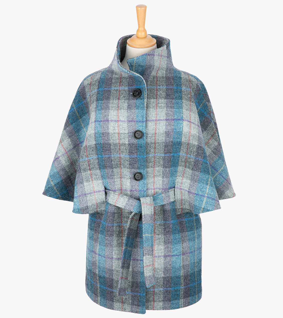 Harris Tweed belted cape in Lavender, the colour is blue, lilac and grey check, with a purple and red overcheck.The cape has 4 buttons, a belt and a collar that can be worn up or folded down. It also has two pockets. It is a traditional cape style at the top but slightly more fitted through the hips. It has a stunning silky lining and comes in sizes small to large.