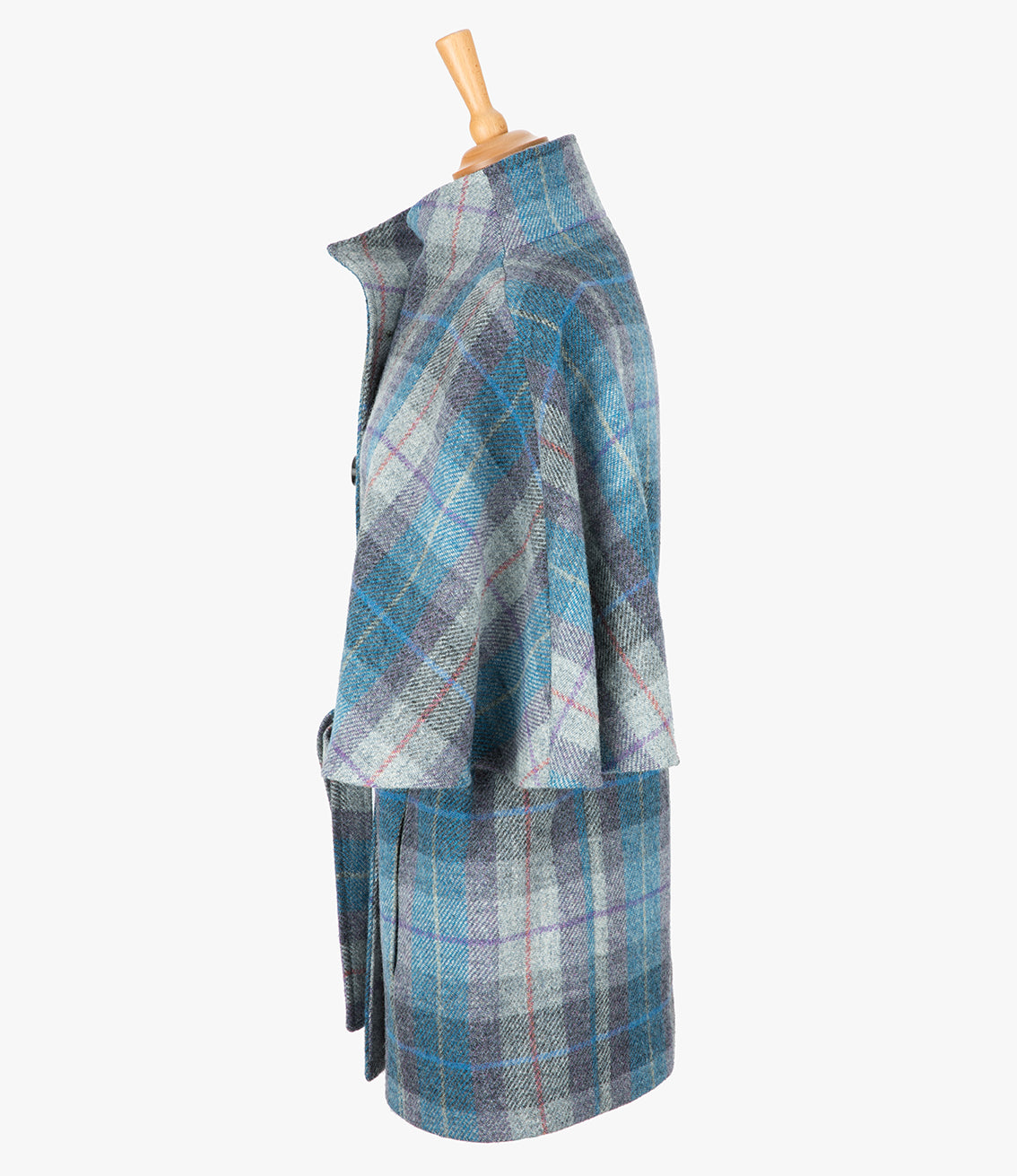 This is the side view of the belted cape in Lavender, the colour is blue, lilac and grey check, with a purple and red overcheck. You can see the collar stood up and the sleeves of the cape which come mid-way down the arm. It has two pockets and ties at the waist for a neat silhouette.