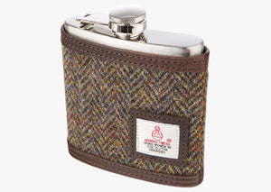 Harris Tweed Hip flask in brown herringbone. The cover is Harris tweed and brown leather. The hip flask holds six ounces and is made from stainless steel, the Harris tweed is edged with brown leather. It also has a small square Harris Tweed logo on the bottom right.