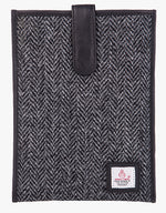 Harris Tweed tablet case in charcoal herringbone, trimmed with leather. This case has a magnetic closing and a small Harris Tweed logo at the bottom of the case.