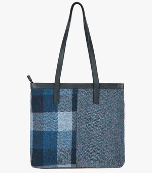 This is the reverse side of the Harris Tweed shopper with navy blue leather handles that sit comfortably on the shoulder. It also has a navy blue leather trim around the top of the bag. The bag is designed in two halves, the left half is Lavender Harris Tweed,comprising lilac, grey and blue check. The right side is a subtle purple and black check.