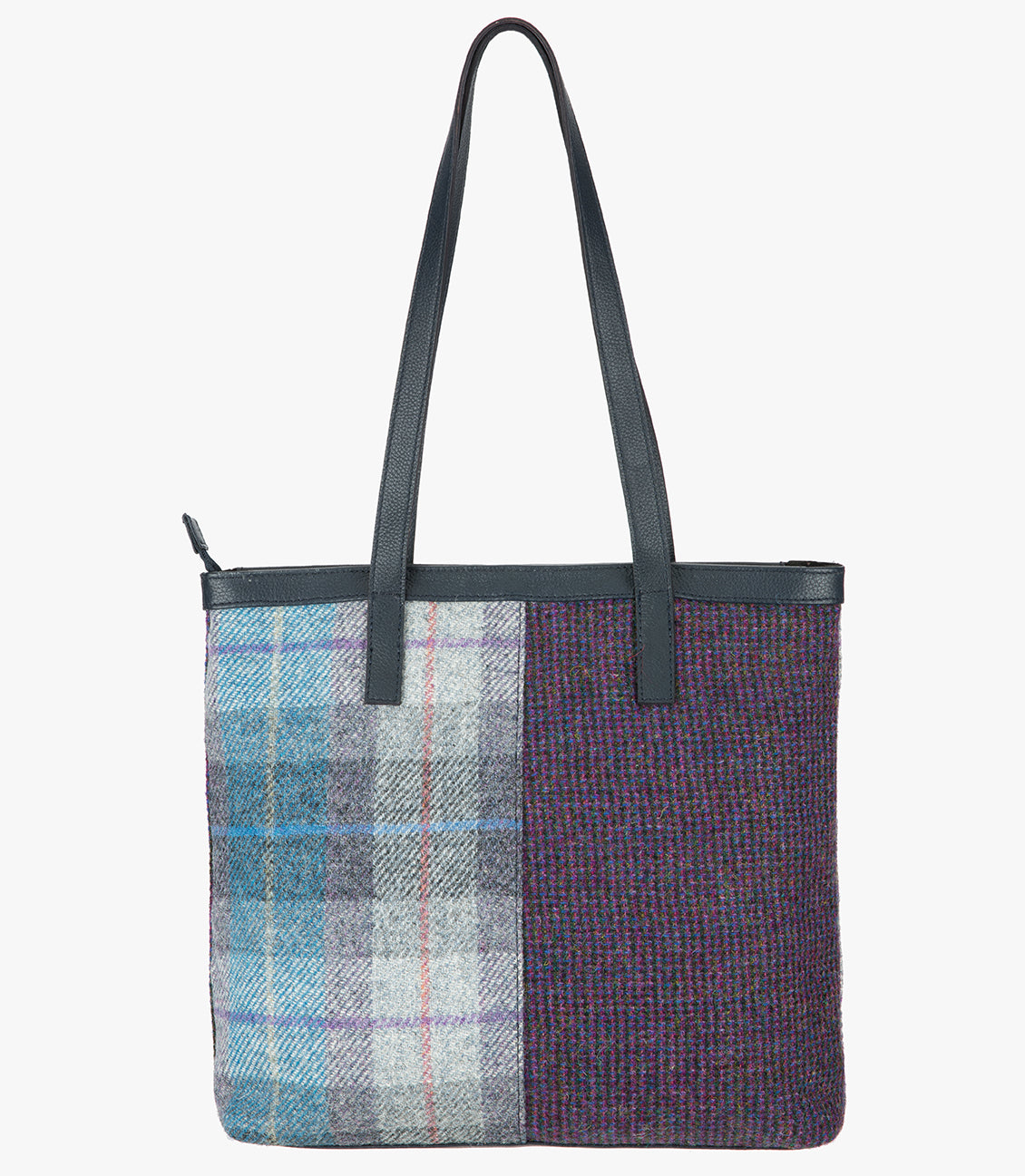 Reverse side of the Harris Tweed shopper with a navy blue leather handle that sits comfortably on the shoulder. It also has a navy blue leather trim around the top of the bag. The bag design is in two halves, the left half is Lavender Harris Tweed, which is lilac, grey, and blue check. The right side is a subtle purple and black check.