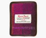 This is the front of the Harris Tweed card holder in pink check, it is a dark pink and bright pink check with an orange overcheck.  It is trimmed in brown leather. This card and note holder has room for 3 cards. It has a rectangular Harris Tweed logo on the front.  
