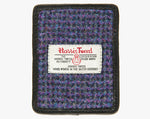 This is the front of the Harris Tweed card holder in violet, it is a purple, black, pink and blue subtle check design and is trimmed in black leather. This card and note holder has room for 3 cards. It has a rectangular Harris Tweed logo on the front.  