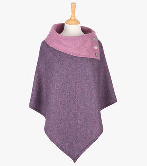 Tweed poncho in damson herringbone. It drops over the head and drapes gently over the shoulders. It comes mid-way down the arms and finishes at a point at the front. It has a folded collar in a contrasting light pink with 3 Celtic buttons in silver on the right hand side.
