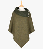 Tweed poncho in forest green. It drops over the head and drapes gently over the shoulders. The colour is forest green herringbone. It comes mid-way down the arms and finishes at a point at the front. It has a folded collar in a contrasting dark green with 3 Celtic buttons in silver on the right hand side.