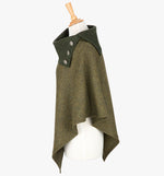 Side view the poncho in forest green. It drops over the head and drapes gently over the shoulders. It comes mid-way down the arms and finishes at a point at the front. The colour is forest green herringbone.  It has a contrasting folded collar in dark green with 3 Celtic buttons in silver.