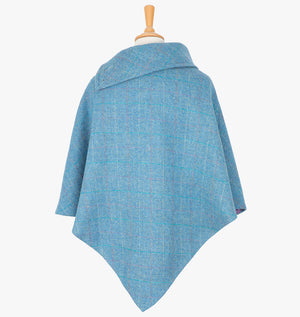 Rear view of the sky poncho, this drops over the head and drapes gently over the shoulders. It comes mid-way down the arms and finishes at a point at the back.. It has a folded collar with 3 button holes on the left.