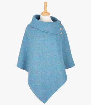 Harris Tweed poncho in Sky blue, it has a folded over cowl collar with 3 Celtic buttons detail.