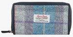 Harris Tweed purse in Lavender check with a navy leather trim.  It also has a Harris tweed logo on the front.