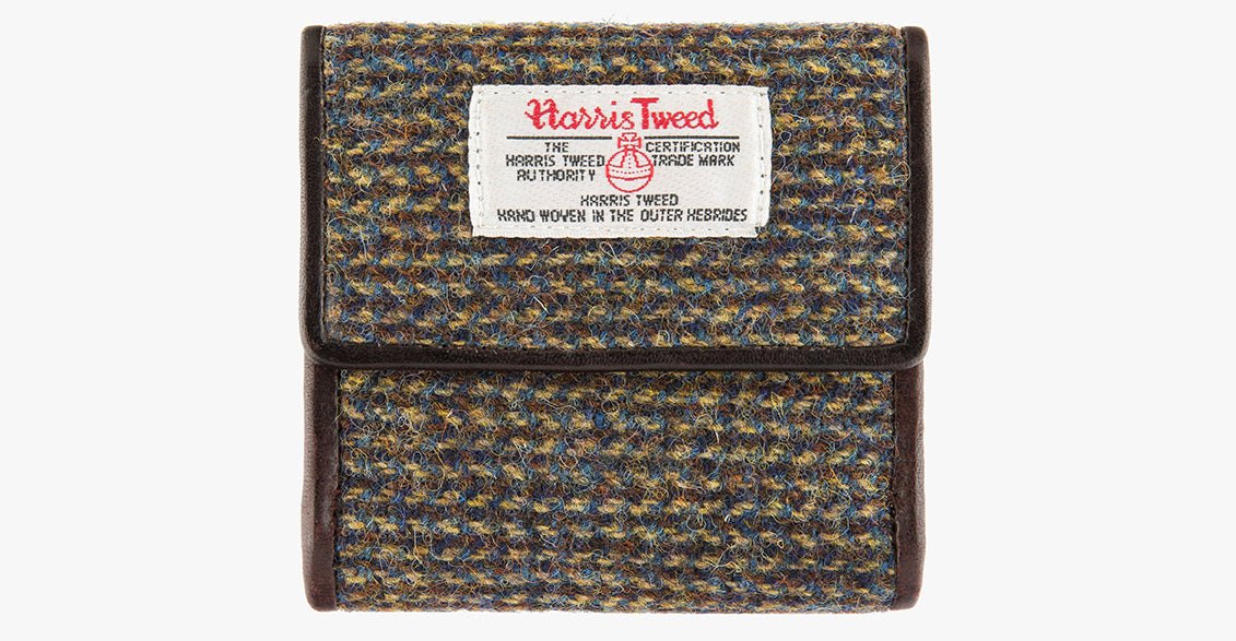 Harris Tweed purse in Heath with a brown leather trim.  It also has a Harris tweed logo on the front.