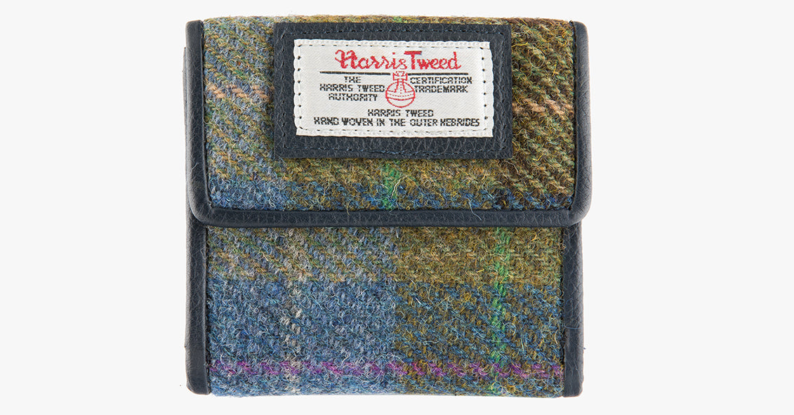 Harris Tweed purse in denim sage check with a blue leather trim. The colour is blue, green and brown check. It also has a Harris tweed logo on the front